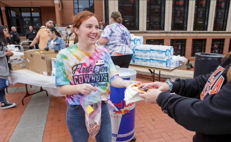 A staff member wearing a brightly-colored tie-dyed t-shirt featuring a 