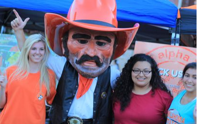 Three female students next to the OSU mascot, Pistol Pete.