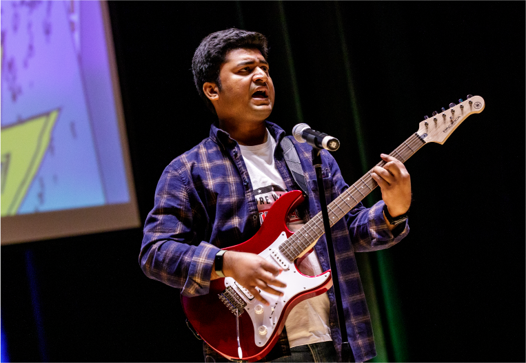 Student singing and playing guitar at SUAB's Talent Show